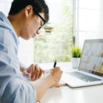 man with eye glasses working on laptop from home