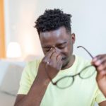 A man suffering from gritty eyes rubbing his eyes