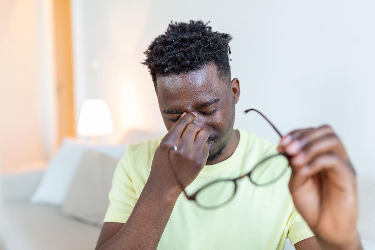 A man suffering from gritty eyes rubbing his eyes