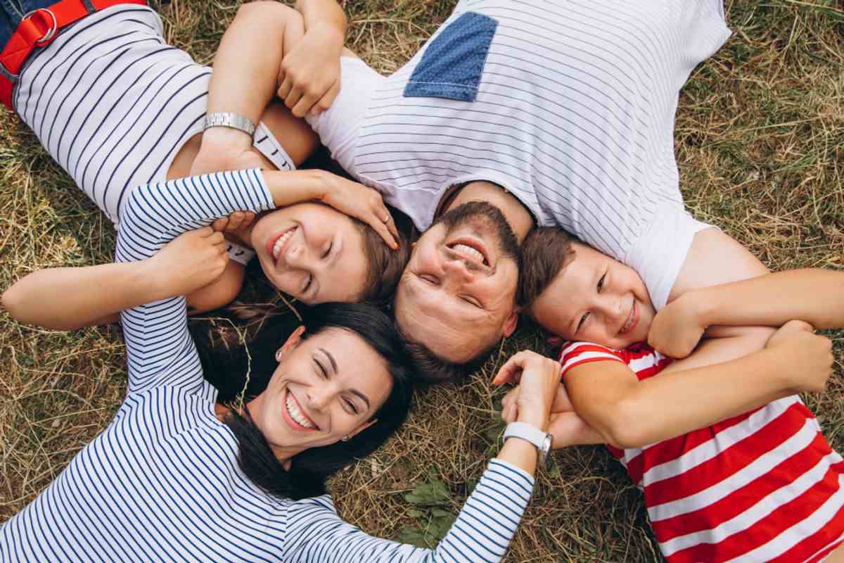 Parents with their kids laying on grass
